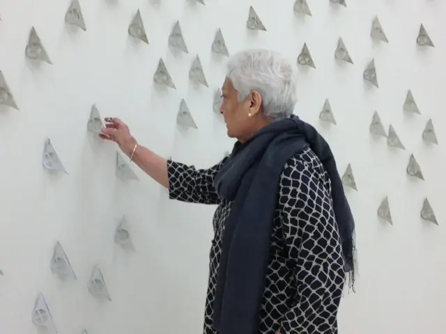 Zarina installing a wall work