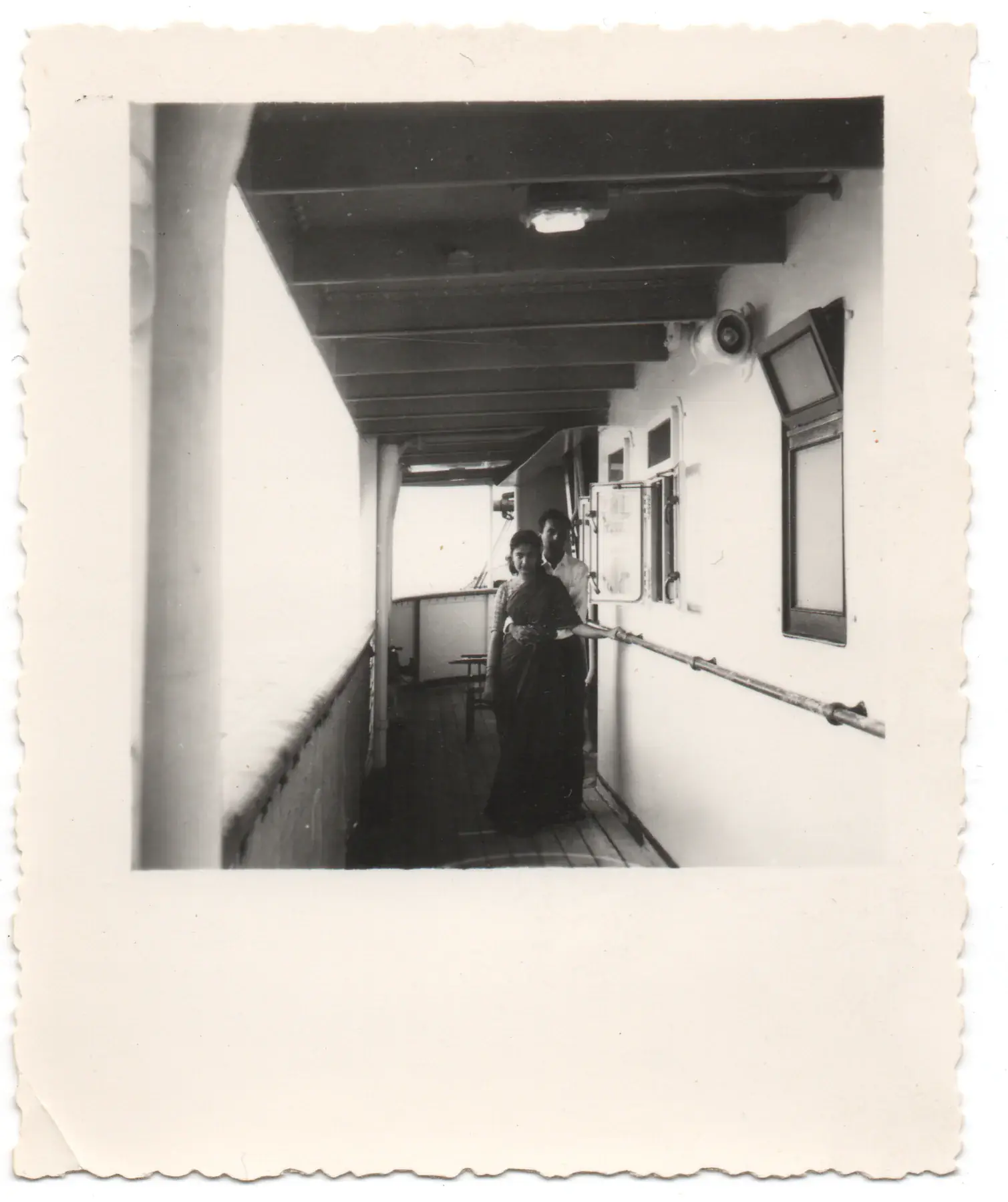 Zarina standing on the covered deck of a ship during the Bangkok years
