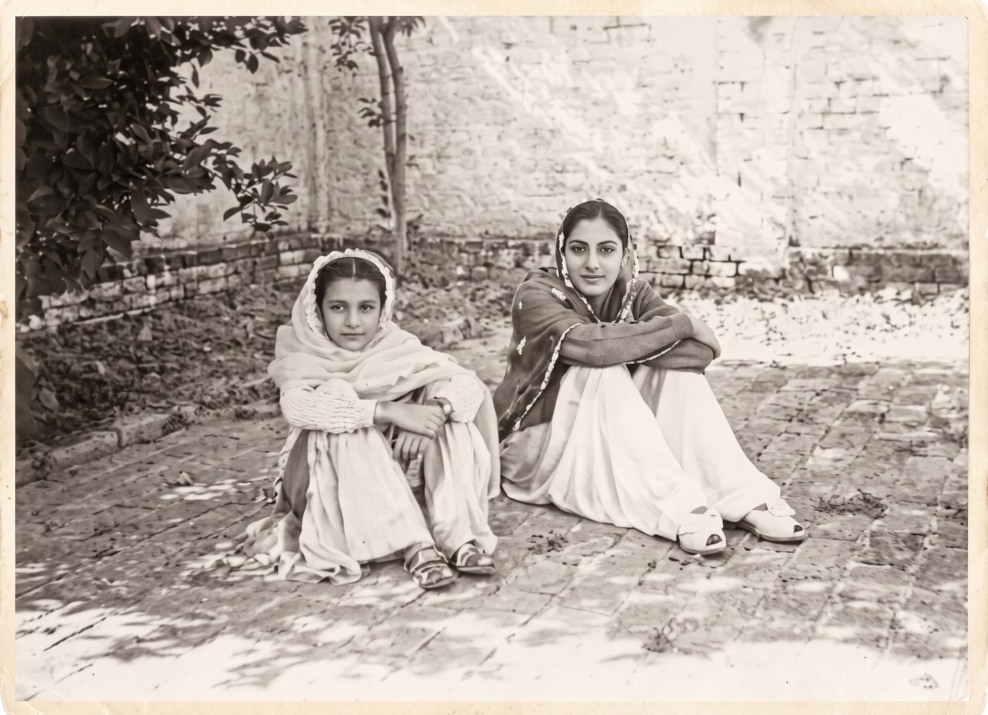 Zarina, left, and her sister Rani seated outdoors in Aligarh